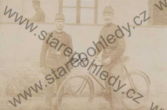  - Na pohlednici jsou tři vojáci z nich jeden drží kolo